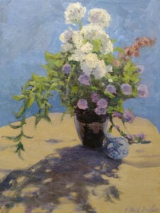 Herb blossoms a vase and a ceramic bird on a table