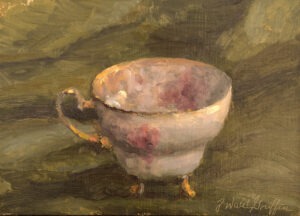 A diminutive footed teacup on green satin