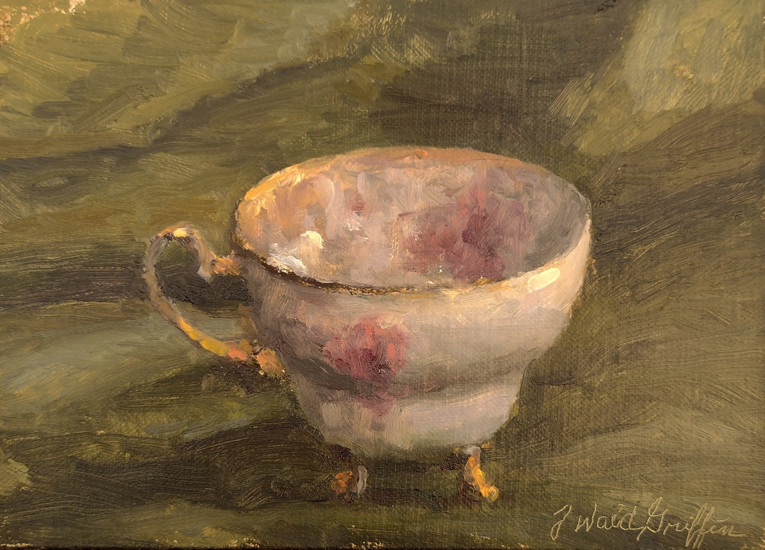 A diminutive footed teacup on green satin