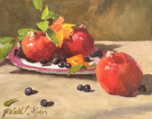 Pomegranates and blueberries with a plate on a tabletop